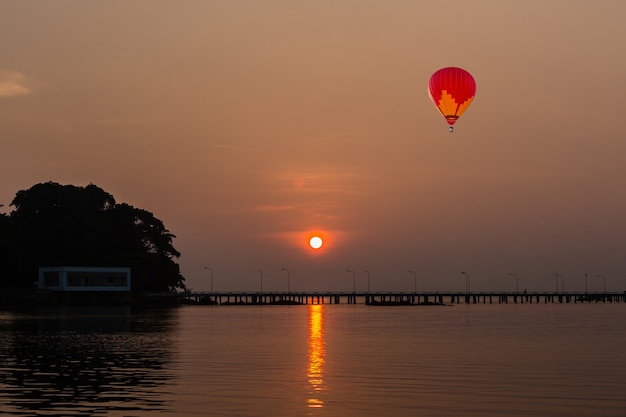 color globo de aire caliente con salida del sol en el puente y el mar