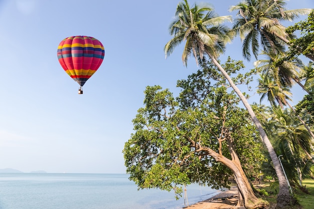 color globo de aire caliente sobre el mar en el cielo azul