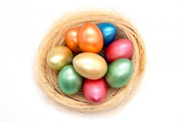 color de los huevos de pascua en la cesta aislada en blanco