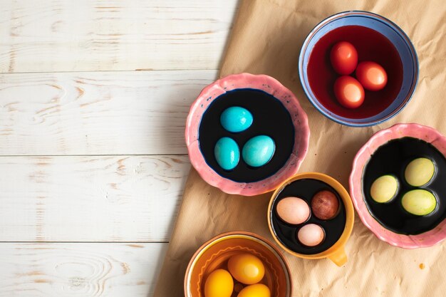 Colorear huevos de Pascua en tazones con pinturas en la cocina de casa