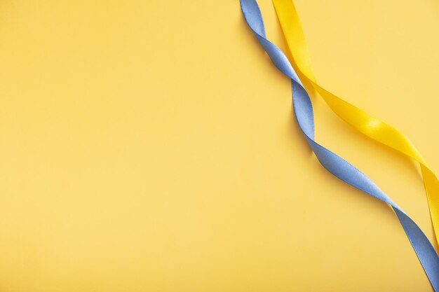 Colores amarillo y azul Cinta de la bandera de Ucrania sobre un fondo amarillo con espacio de copia
