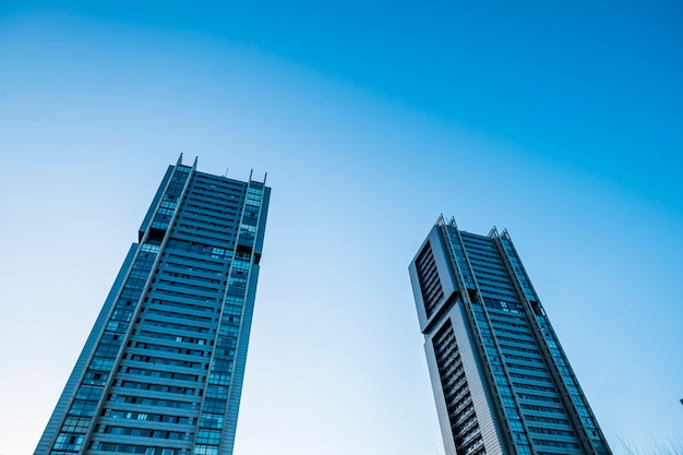 Colores de tonos fríos azules de rascacielos con luz solar: mirando hacia la perspectiva, vista a la ciudad de oficinas y distrito financiero con personas de bancos y seguros en el trabajo