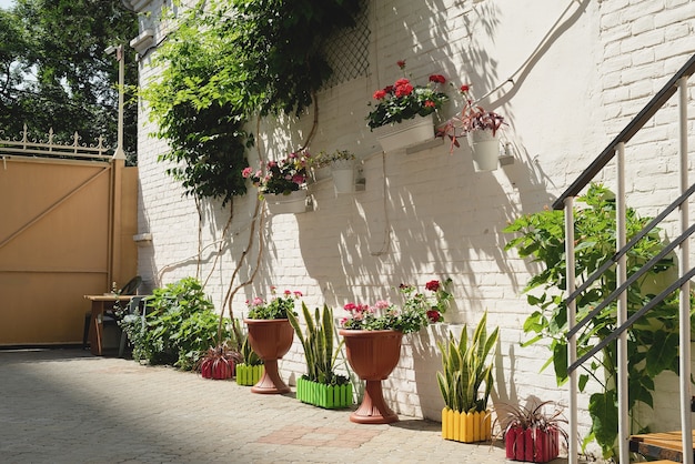 Colorfull floral street con pared de ladrillo blanco en la ciudad mediterránea