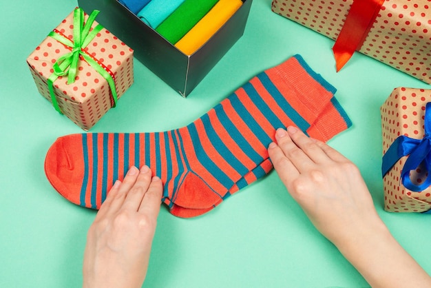 Colorida colección de calcetines de algodón como regalo en manos de mujer.