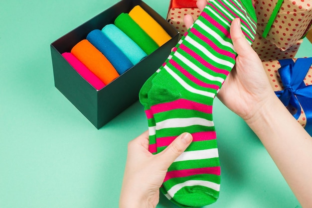 Colorida colección de calcetines de algodón como regalo en manos de mujer.