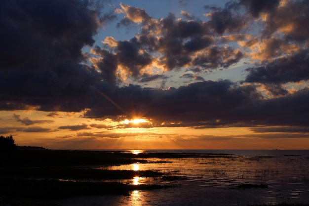 Una colorida puesta de sol y las nubes oscuras sobre el mar.