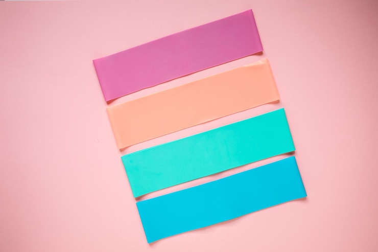 Foto coloridas bandas elásticas de resistencia de goma para deporte o fitness en el fondo rosa, equipo de entrenamiento.