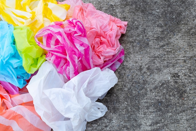 Coloridas bolsas de plástico desechables sobre cemento.