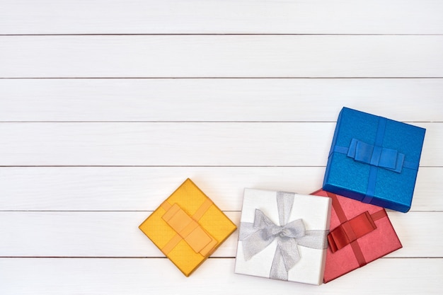 Coloridas cajas de regalo en madera blanca.