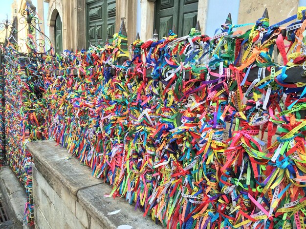 Coloridas cintas de deseos unidas a la valla de la iglesia