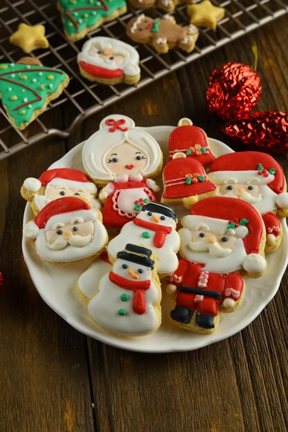 Coloridas galletas de azúcar glas de Navidad con varias formas en el fondo de madera.