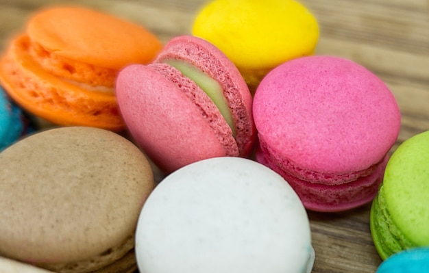 Coloridas galletas Macaron en bandeja de madera