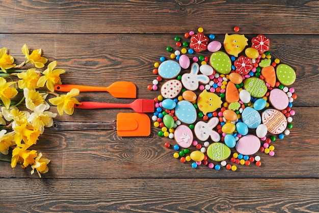 Coloridas galletas de pascua y espátulas sobre la mesa.