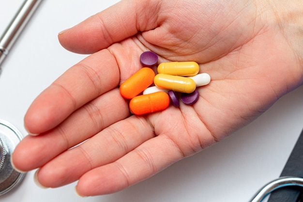 Coloridas píldoras médicas, tabletas en mano. Protección farmacológica, tratamiento de virus, antivirales, concepto de enfermedades.
