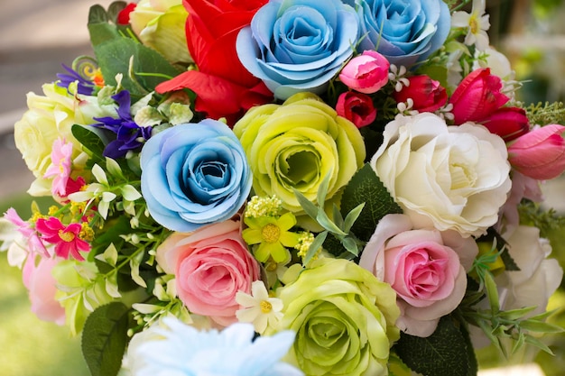 Coloridas rosas de plástico y otras flores para decoración y muebles en el jardín al aire libre