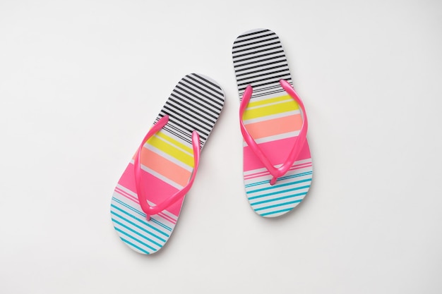 Coloridas zapatillas de playa de verano para mujeres con rayas de colores Un nuevo par de zapatos sobre un fondo blanco