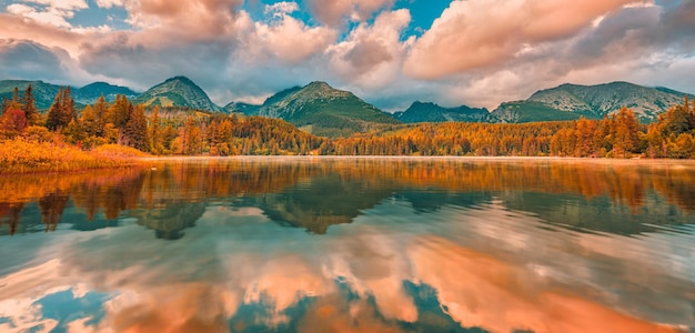 El colorido amanecer del otoño nubla el cielo sobre el lago. Paisaje natural panorámico, agua de ensueño pacífica