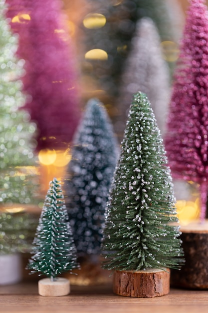 Colorido árbol de navidad sobre fondo de madera, bokeh. concepto de celebración navideña. tarjeta de felicitación.