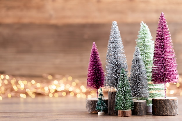 Colorido árbol de Navidad sobre fondo de madera, bokeh. Concepto de celebración navideña. Tarjeta de felicitación.