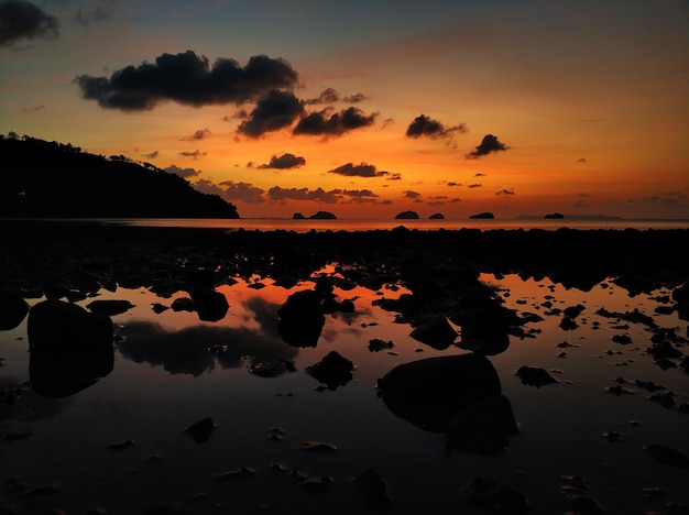 Colorido atardecer en la playa. Reflejo del cielo del atardecer en el agua.