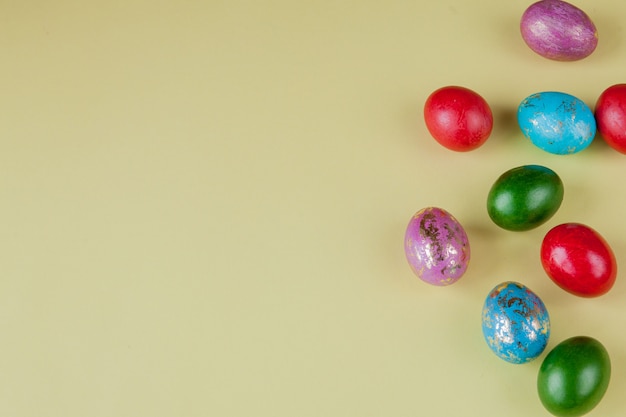 Colorido borde lateral del huevo de Pascua sobre un fondo de papel amarillo