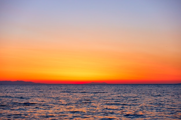 Colorido cielo anaranjado y el mar al atardecer y fondo con espacio para su propio texto