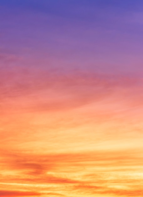 Colorido cielo de puesta de sol vertical por la noche con nubes de luz solar amarillas y violetas anaranjadas