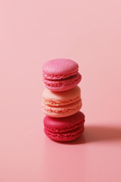 Colorido de doces franceses macaroons em fundo de cor pastel, copie o espaço.