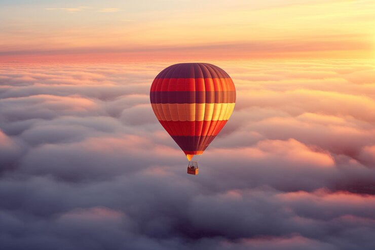 Un colorido globo aerostático flota sobre un mar de nubes al atardecer
