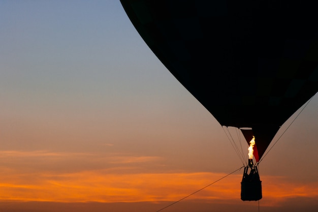 Colorido globo aerostático flotando al atardecer