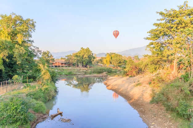 Colorido globo aerostático sobre montaña y río Song VangVieng, Laos