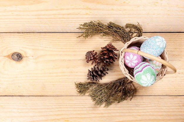 Colorido huevo de pascua en la canasta sobre una mesa de madera Felices Pascuas