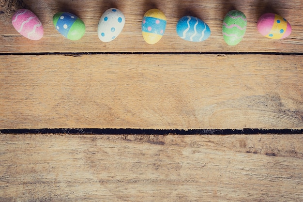 Colorido huevo de Pascua en el fondo de madera con espacio.