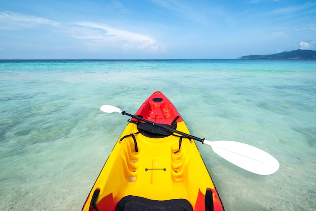 Colorido kayak en la playa tropical con cielo azul