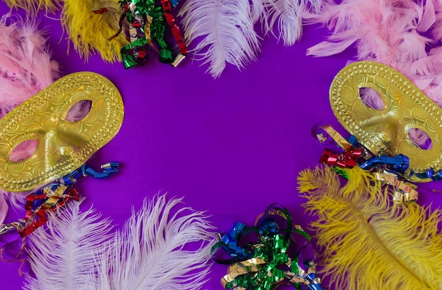 Colorido marco de carnaval con máscaras y plumas y fondo morado