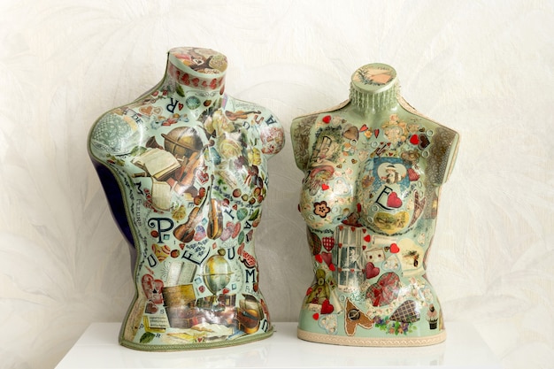 Colorido par de bustos de maniquí vintage sobre una mesa con decoración de decoupage en forma masculina y femenina