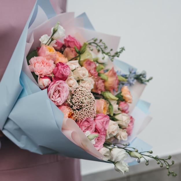 Colorido ramo de diferentes flores frescas en manos de una mujer florista