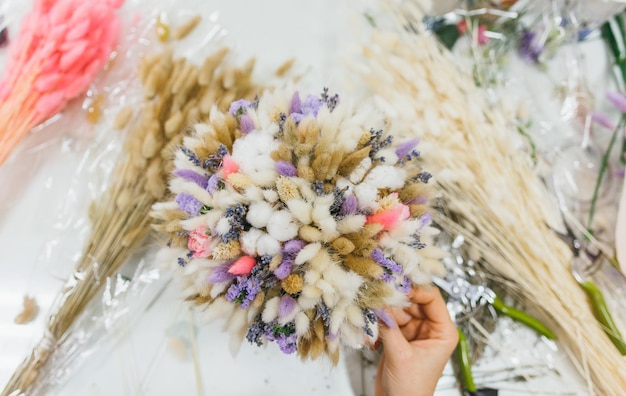 Colorido ramo de diferentes flores secas flores muertas en manos de una mujer florista