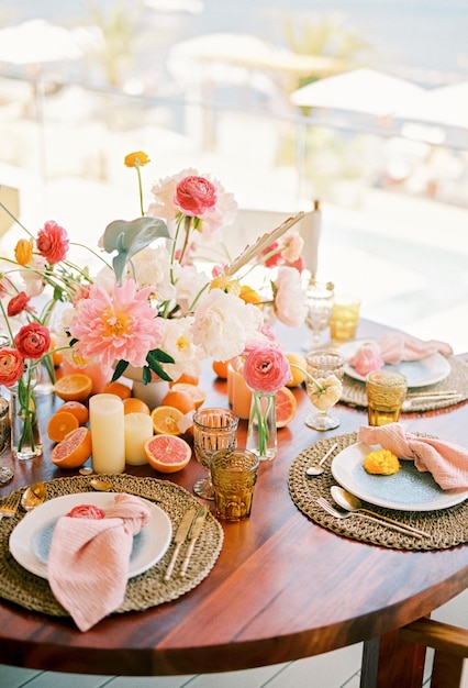 Un colorido ramo de flores se encuentra en una mesa festiva con frutas