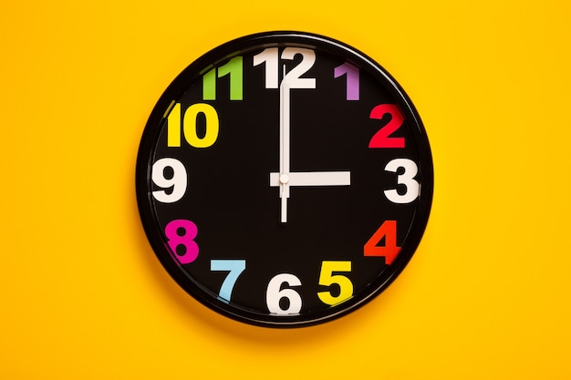 Foto el colorido reloj de pared muestra las tres en punto