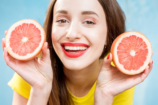 Colorido retrato de una hermosa mujer rodajas de pomelo sobre fondo amarillo