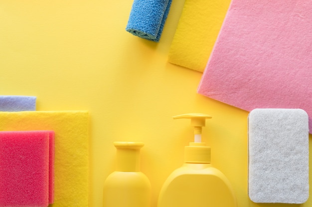 Colorido set de limpieza para diferentes superficies en cocina, baño y otras habitaciones. Lugar vacío para texto o logotipo sobre fondo amarillo. Concepto de servicio de limpieza. artículos de limpieza limpieza regular.