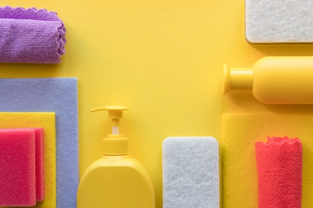 Colorido set de limpieza para diferentes superficies en cocina, baño y otras habitaciones. Lugar vacío para texto o logotipo sobre fondo amarillo. Concepto de servicio de limpieza. artículos de limpieza limpieza regular.