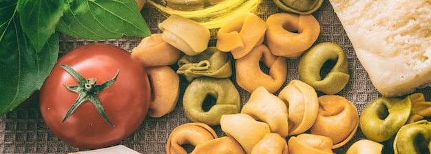 Colorido tortellini pasta tomates queso aceite de oliva y pancarta de albahaca