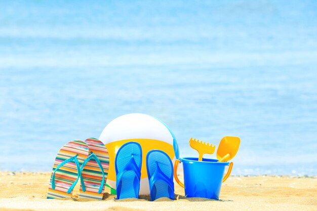 Coloridos accesorios de playa en la arena a la orilla del mar Concepto de vacaciones