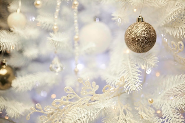 Coloridos adornos navideños colgando del árbol de navidad blanco. árbol de navidad blanco.