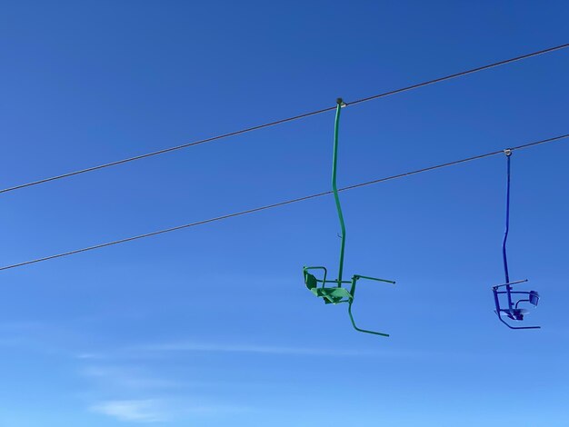 Los coloridos asientos del ascensor de esquí en las montañas en un fondo de cielo azul transporte a la cima