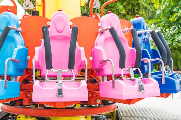Coloridos asientos de montaña rusa en el parque de atracciones