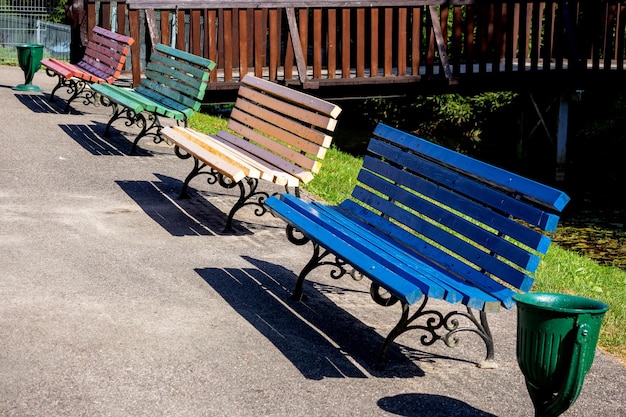 Coloridos bancos de madera con patas de metal fundido en el parque