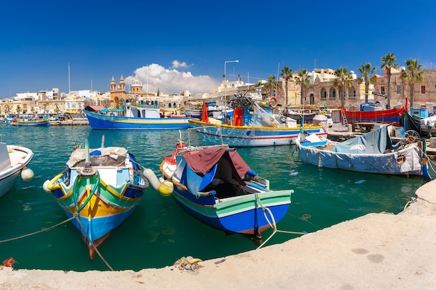 Coloridos barcos de ojos tradicionales Luzzu en el puerto del pueblo pesquero del Mediterráneo Marsaxlokk, Malta